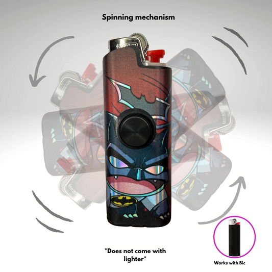 A lighter case with a Batman mashup with a pokemon graphic design, featuring a black central button and a red top tip. The image includes a 'Spinning mechanism' label with arrows showing the lighter case rotating inside a clear casing, a note saying 'Does not come with lighter', and an inset showing compatibility with a Bic lighter.